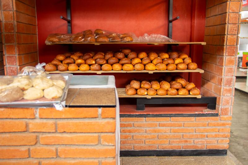 Repisas llenas de pan dulce en una panadería de ladrillo