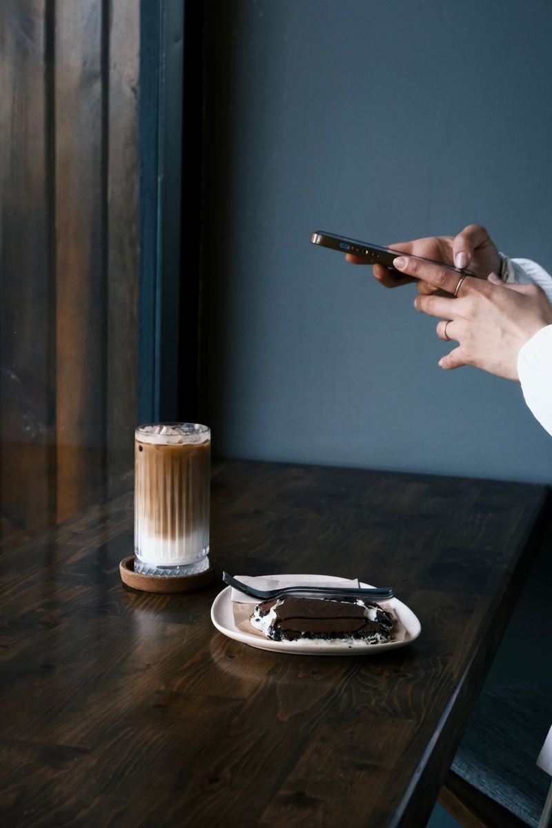 Una mano apunta la cámara del celular al mostrador de una cafetería